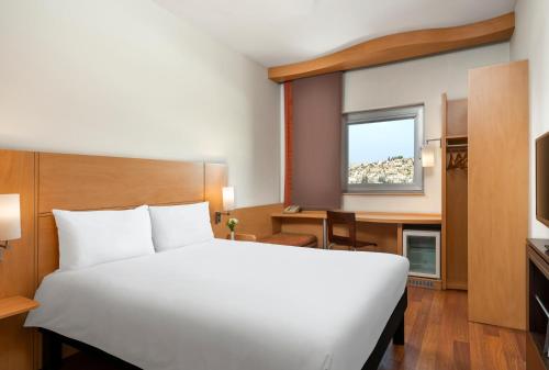 sypialnia z białym łóżkiem, biurkiem i oknem w obiekcie Ibis Gaziantep w mieście Gaziantep