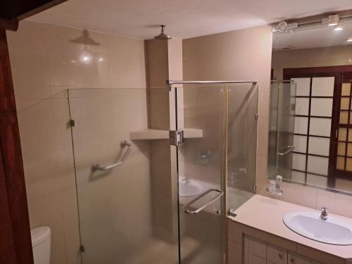 een badkamer met een glazen douche en een wastafel bij Wild Orchid Resort in Angeles