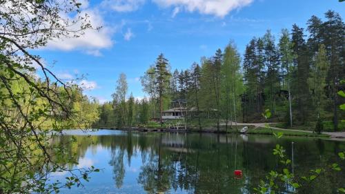a view of a lake with a house in the distance at Premium Chalet 4109 Blue in Vierumäki
