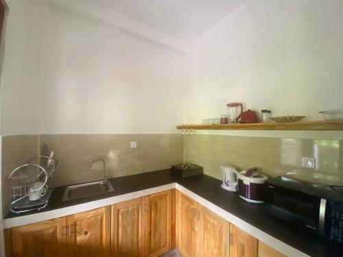 a kitchen with a sink and a microwave at The Cozy Nest in Hikkaduwa