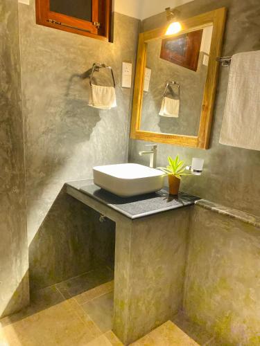 a bathroom with a sink and a mirror at The Cozy Nest in Hikkaduwa
