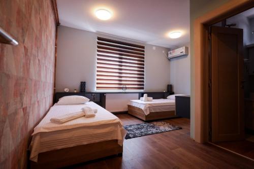 a bedroom with two beds and a window at Domaćin Komšijska Gostiona in Zrenjanin
