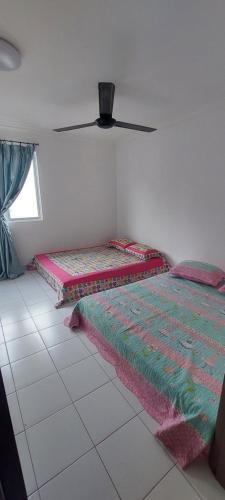 a room with two beds and a ceiling fan at Nur Homestay Residensi Afamosa mslim guest only in Kampong Alor Gajah