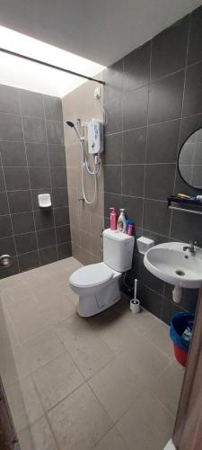 y baño con aseo y lavamanos. en Nur Homestay Residensi Afamosa mslim guest only en Kampong Alor Gajah