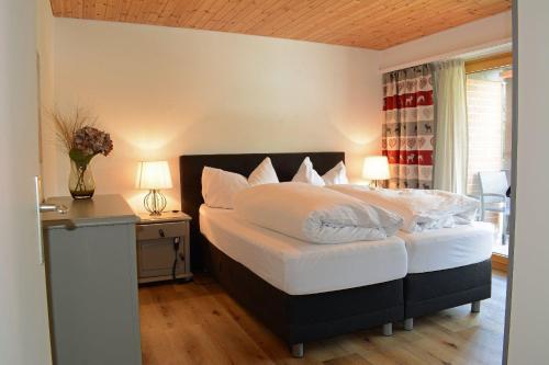 a bedroom with a bed and a desk with two lamps at I dr Rehwiesa A25 in Arosa