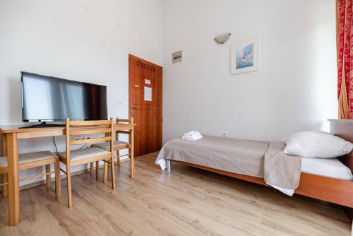 a bedroom with a bed and a desk with a flat screen tv at Villa Heaven in Donji Zemunik