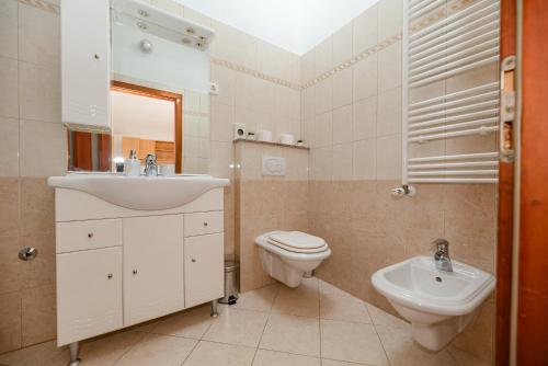 a white bathroom with a sink and a toilet at Villa Heaven in Donji Zemunik