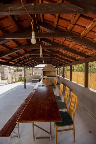 a long wooden table and chairs under a roof at Villa Heaven in Donji Zemunik