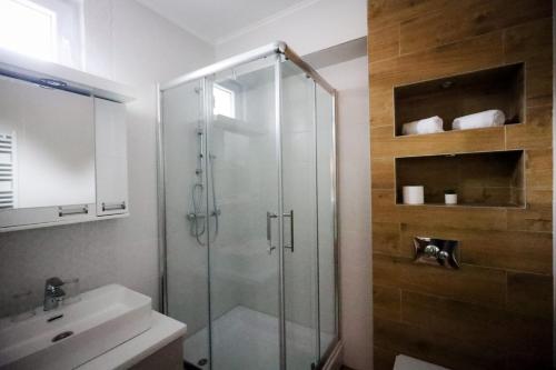 a bathroom with a glass shower and a sink at Domaćin Komšijska Gostiona in Zrenjanin