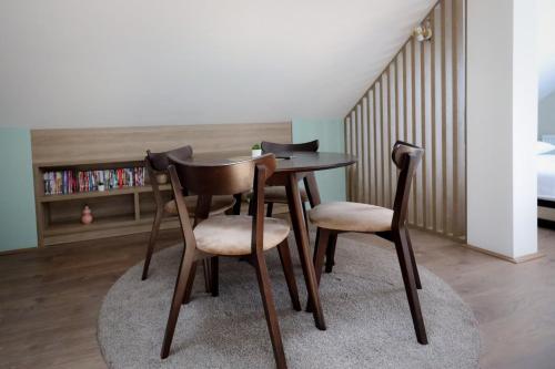 a table and chairs in a room with a bed at Domaćin Komšijska Gostiona in Zrenjanin