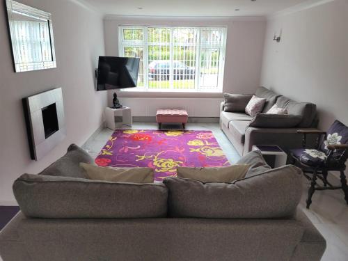 a living room with two couches and a rug at Smitten House 4 Bedroom RHYL in Rhyl