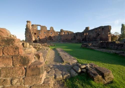 un viejo castillo con un campo verde delante de él en Albany House en Penrith