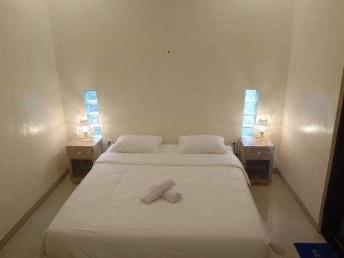 - un lit avec une serviette blanche dans la chambre dans l'établissement Yanti Guest House, à Canggu
