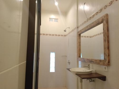 La salle de bains est pourvue d'un lavabo et d'un miroir. dans l'établissement Yanti Guest House, à Canggu