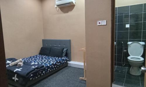 een kleine kamer met een bed en een toilet bij NZ Villa Roomstay in Kangar