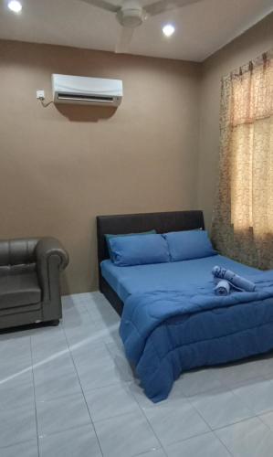 a bedroom with a blue bed and a air conditioner at NZ Villa Roomstay in Kangar