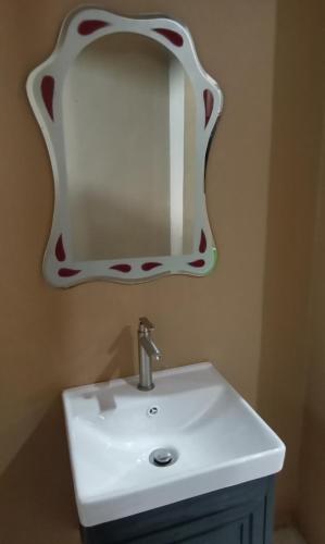 a bathroom with a white sink and a mirror at NZ Villa Roomstay in Kangar
