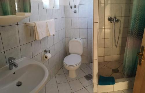 a bathroom with a toilet and a sink and a shower at Aurora Apartments-Nin- 25m to the Beach in Nin