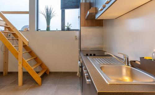uma cozinha com um lavatório e uma escada em Le Studio Compostelle by Maison Brasseurs d'Etoiles em Liège