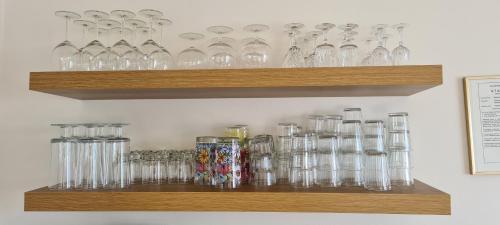 un montón de vasos sentados en un estante en Guesthouse Stekkatún, en Skálafell