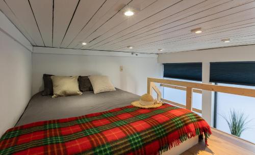 ein Schlafzimmer mit einem Bett mit einer karierten Decke in der Unterkunft Le Studio Compostelle by Maison Brasseurs d'Etoiles in Lüttich