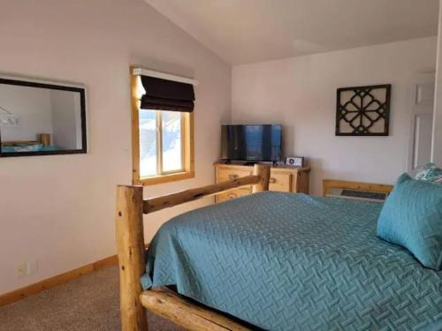 a bedroom with a bed and a television and a window at Harbour Village Retreat in Garden City