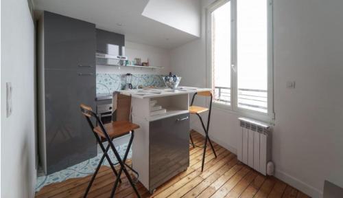 a kitchen with a counter and two chairs in it at Solo traveler's best stop near Paris in Bagnolet