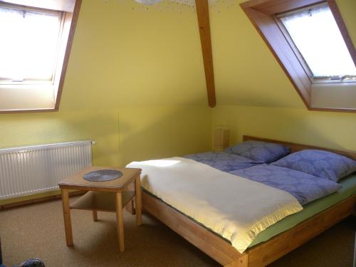 1 dormitorio con 1 cama, 2 ventanas y mesa en Ferienwohnung an der Schorfheide en Schorfheide
