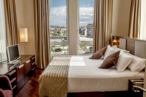 Habitación de hotel con cama y ventana grande en Hotel URH Palacio de Oriol en Santurce