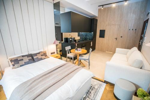 um quarto com uma cama, um sofá e uma mesa em Apartament Migdałowy em Toruń