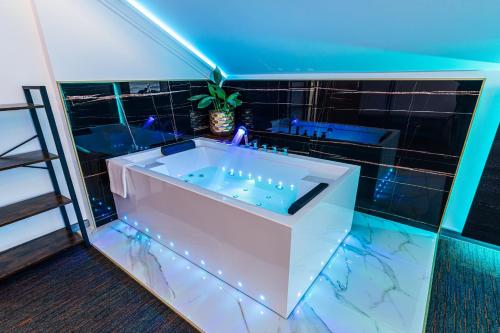 a bathroom with a tub with lights in it at GLAMOUR - Restaurant & SPA in Przeźmierowo