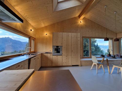 ナンダにあるChalet ski-in ski-out Nendazの木製の壁と大きな窓が備わるキッチン
