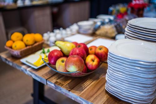 a bowl of fruit on a table with plates at GLAMOUR - Restaurant & SPA in Przeźmierowo