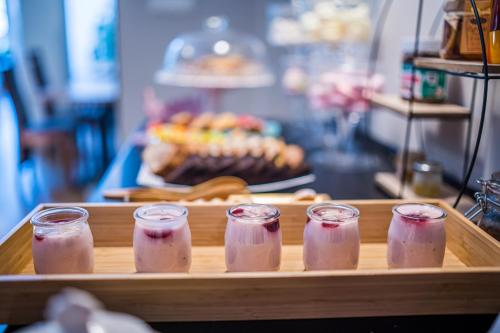 a tray with four jars of pink juice at GLAMOUR - Restaurant & SPA in Przeźmierowo