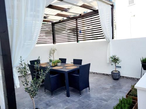 eine Außenterrasse mit einem Tisch und Stühlen in der Unterkunft Apartman Roko in Slatine