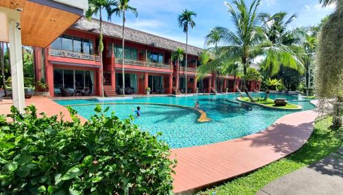 a large swimming pool in front of a building at Mai Morn Resort SHA Plus in Phuket