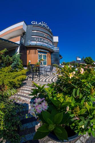 a view of a building with flowers in front of it at GLAMOUR - Restaurant & SPA in Przeźmierowo