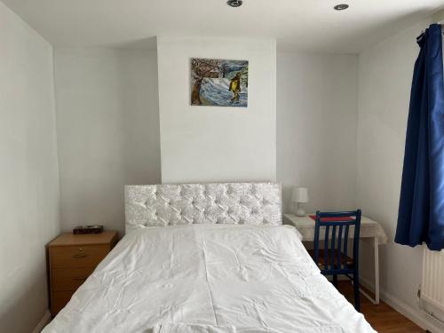 a bedroom with a bed and a picture on the wall at Large Double Bedroom with free on site parking in Kingston upon Thames