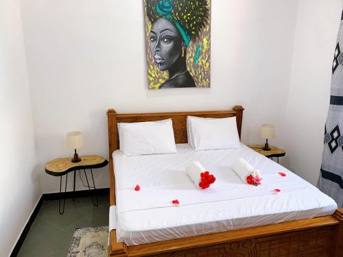 1 dormitorio con 1 cama con una pintura en la pared en Tamu House Pajé Beach, en Paje