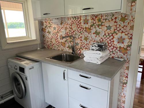 a kitchen with a sink and a washing machine at Nice apartment, rural idyll just outside Karlstad in Karlstad