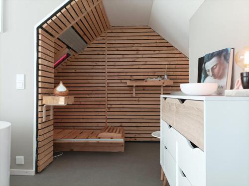 een badkamer met een sauna en een houten muur bij Küken Winterberg in Winterberg