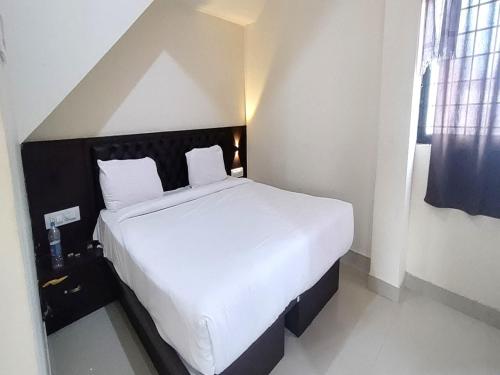 a bedroom with a large white bed in a room at MG Residency in Chikmagalūr