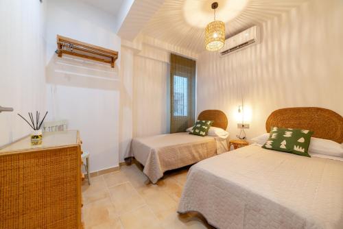 a hotel room with two beds and a window at Apartamento Ronda Genil con parking gratuito in Granada
