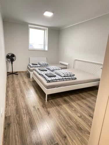 una camera con 2 letti e un pavimento in legno di Anna's guesthouse a Riga