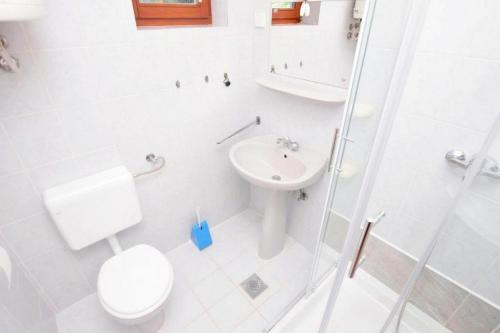 uma casa de banho branca com um WC e um lavatório em Apartments with a parking space Sabunike, Zadar - 19695 em Privlaka