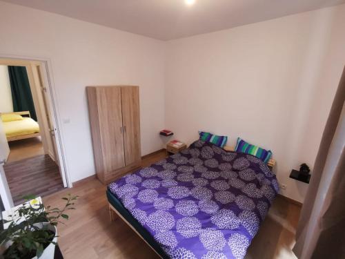 a bedroom with a purple bed in a room at Appartement Prés de la gare RER C-Spacieux 4 pièces in Étampes