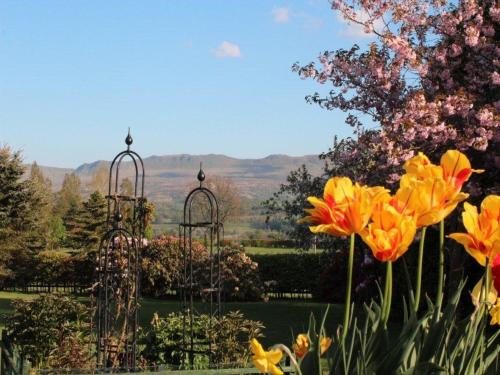 a garden with two metal structures with flowers at Stable Lodge in Drymen