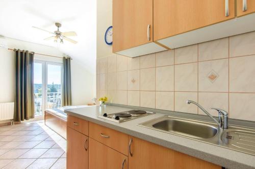 eine Küche mit einem Waschbecken und einem großen Fenster in der Unterkunft Apartments with a parking space Jezera, Murter - 19561 in Jezera