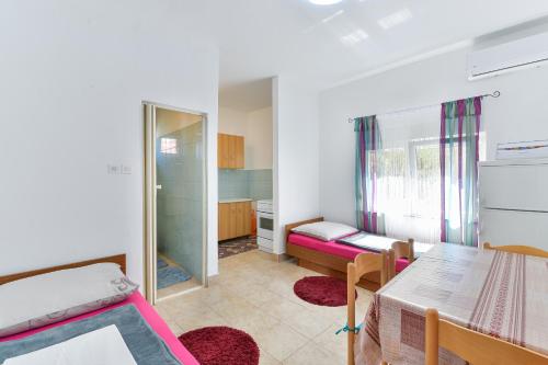 a small room with a bed and a table at Apartments with a parking space Nin, Zadar - 19555 in Nin