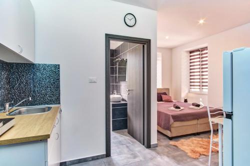 een keuken en een slaapkamer met een bed en een wastafel bij Apartments with a parking space Mali Losinj, Losinj - 19618 in Mali Lošinj